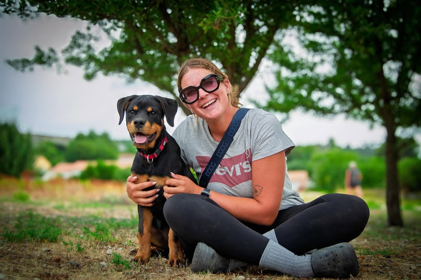 Éducatrice et son chiot rottweiler dans la prairie