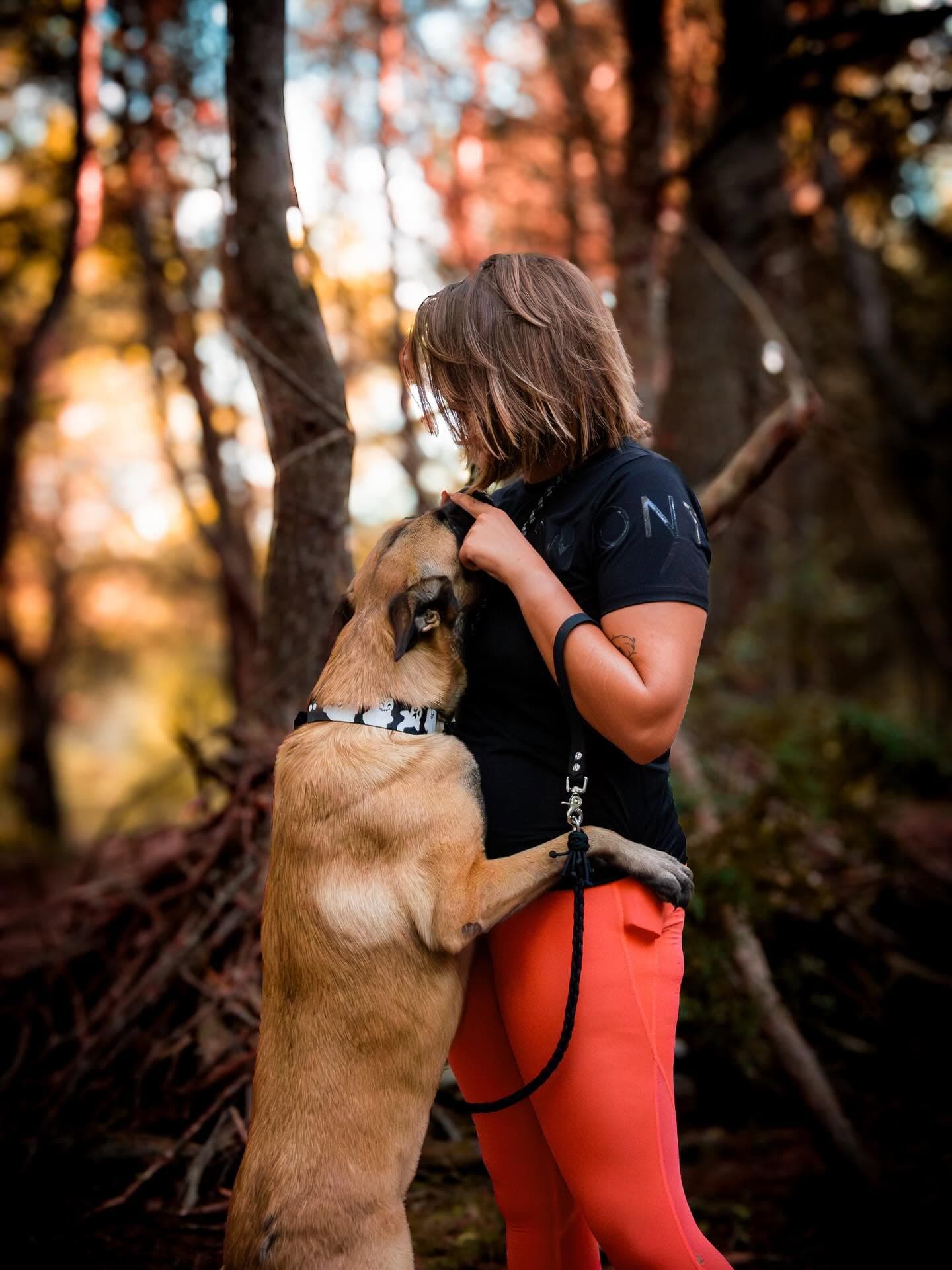 Malinois et sa maîtresse en balade dans la forêt d'automne